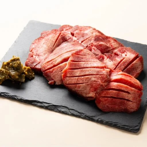 黒いスレート皿に盛った、焼く前の生牛たんのスライス